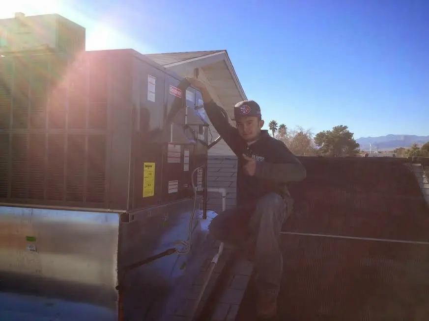HVAC technician performing AC Tune-Up on a rooftop unit in Camas